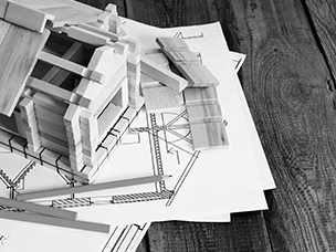A model house being built on a table with plans